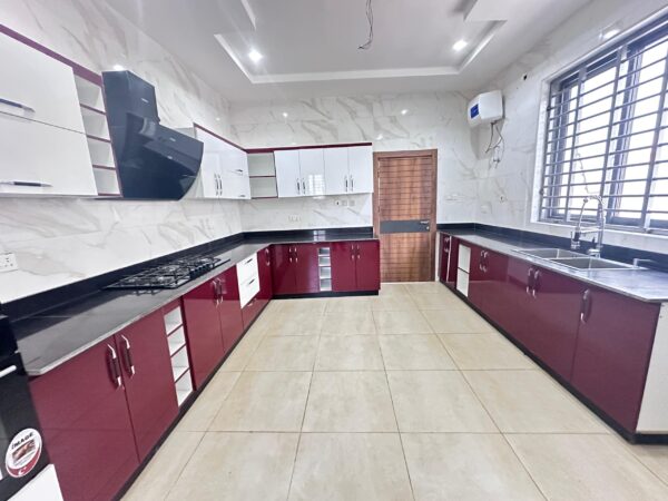 Fully equipped modern kitchen with sleek red and white cabinetry.
