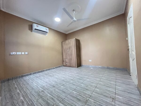 A comfortable bedroom with a built-in wardrobe, air conditioning, and ceiling fan for a relaxing atmosphere.