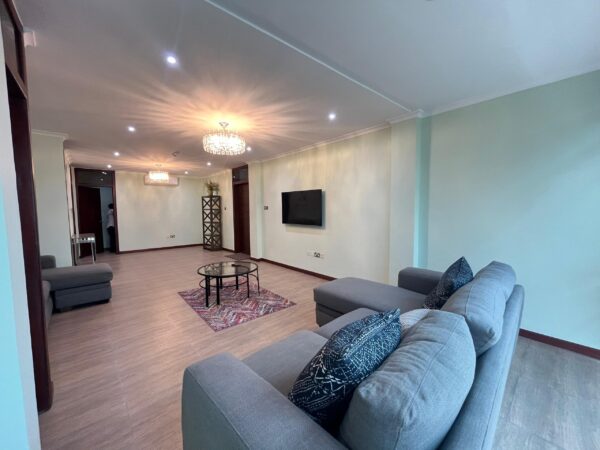 Relax in this spacious and well-lit living room designed for comfort and style.