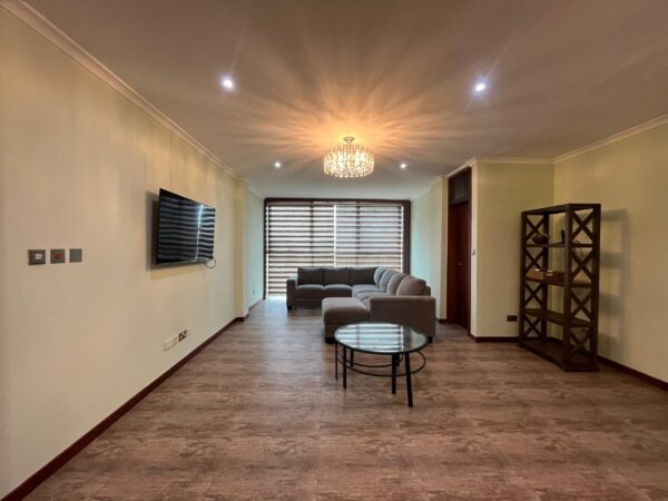 Relax in this spacious and well-lit living room designed for comfort and style.