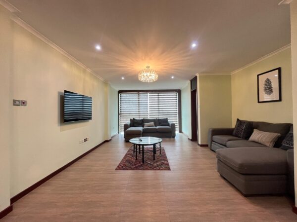 Relax in this spacious and well-lit living room designed for comfort and style.