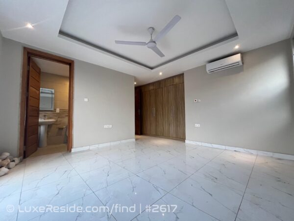 Bedroom with polished tiles, air conditioning, built-in wardrobes, and en-suite bathroom access.