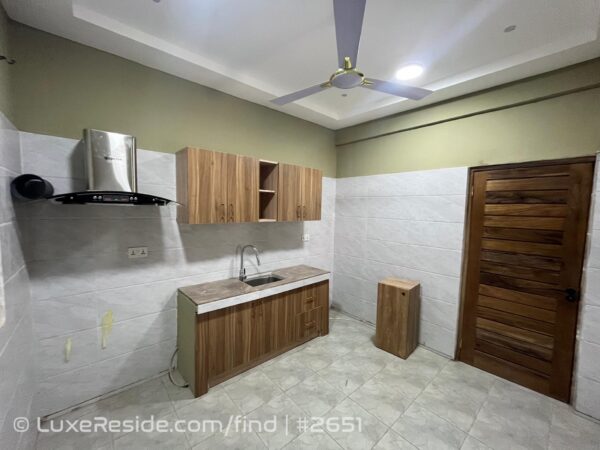 Fitted kitchen space with essential cabinetry and extractor hood.