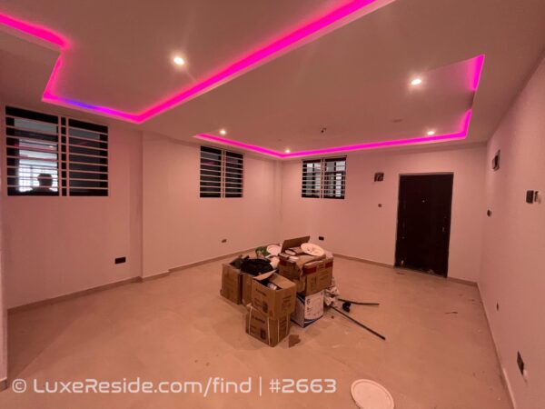 Open-plan living area with tiled floors and recessed ceiling LED lights