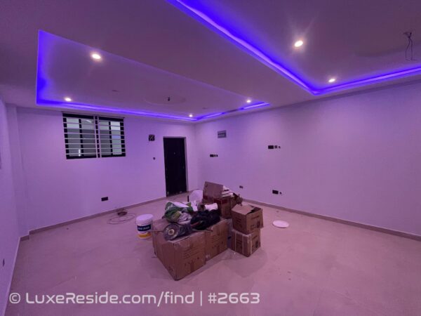 Open-plan living area with tiled floors and recessed ceiling LED lights