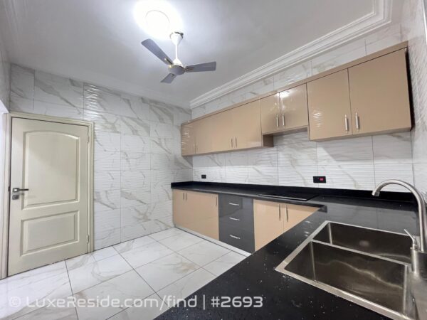 A look at the bright and functional kitchen space with ample cabinet storage.