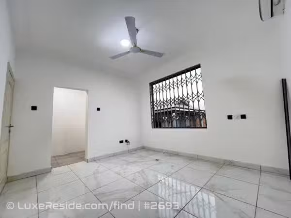 Tiled bedroom with ceiling fan, AC point, and large window with security bars