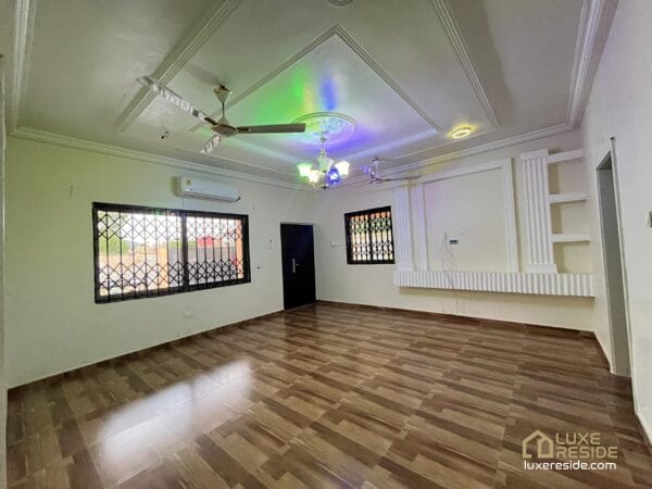 Large living room with tiled floors, ceiling fan, and air conditioner.
