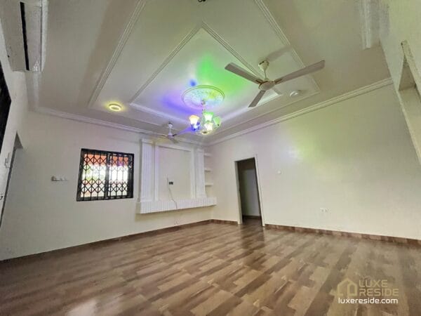 Large living room with tiled floors, ceiling fan, and air conditioner.