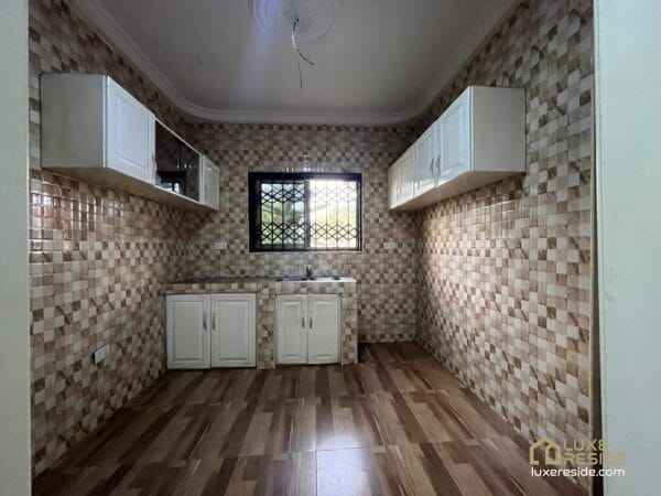 Tiled kitchen with cabinets and ample counter space.