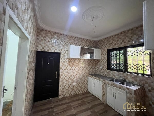 Tiled kitchen with cabinets and ample counter space.