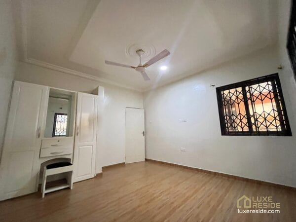 Large living room with tiled floors, and ceiling fan.