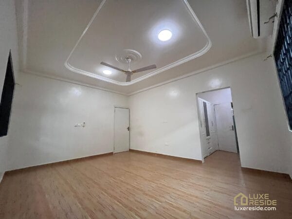 Large living room with tiled floors, and ceiling fan.