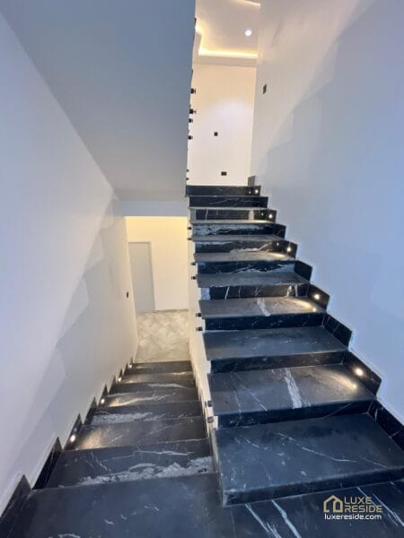 Black marble staircase with lighting along the steps.
