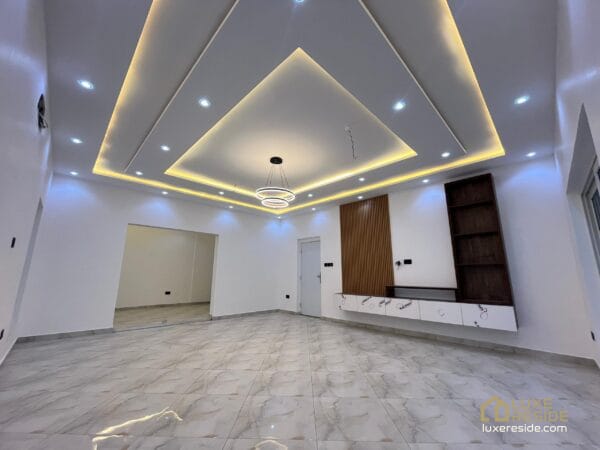 Large, open living room with a stylish ceiling and recessed lighting.
