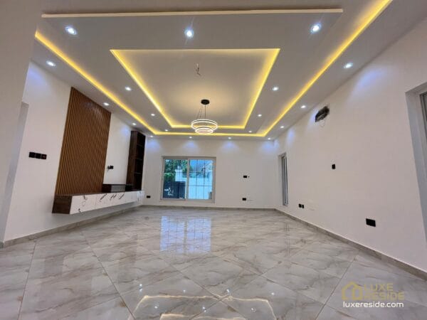 Large, open living room with a stylish ceiling and recessed lighting.
