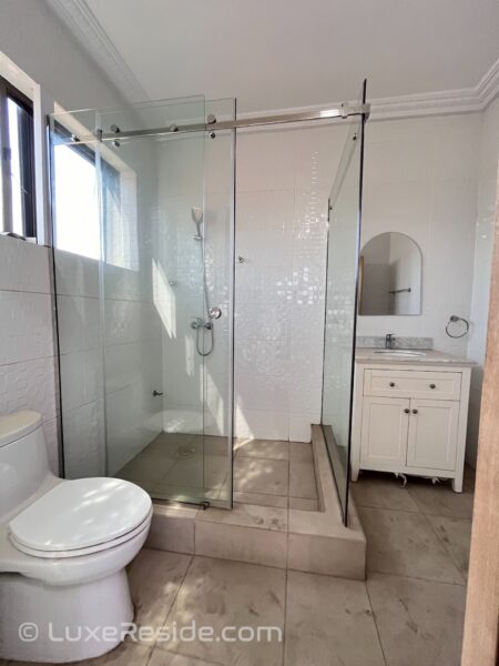 Second bathroom with a glass-enclosed shower and vanity.