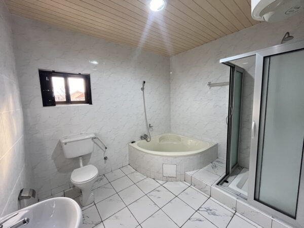Ensuite bathroom featuring both a corner bathtub and walk-in shower.