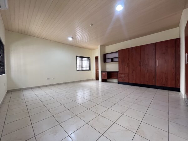 Expansive bedroom with ample built-in storage and natural light.