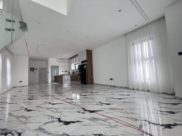 Expansive living area with sleek marble flooring and ample natural light.