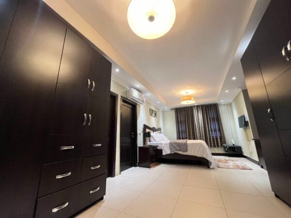 A cozy master bedroom with ample wardrobe space and stylish lighting.
