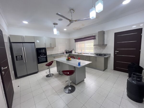Fully equipped kitchen with an island, gas stove, and ample storage—ideal for culinary enthusiasts.