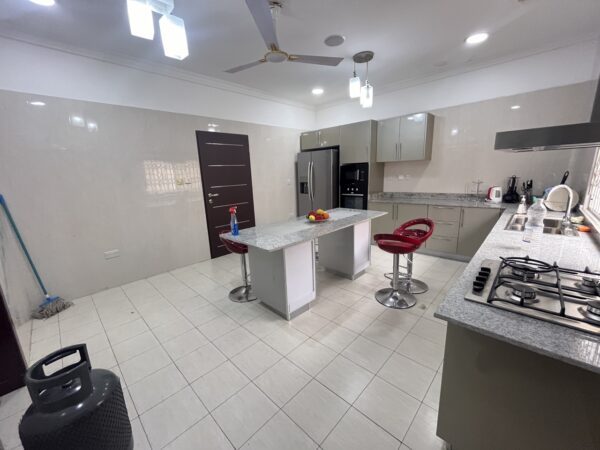 Fully equipped kitchen with an island, gas stove, and ample storage—ideal for culinary enthusiasts.