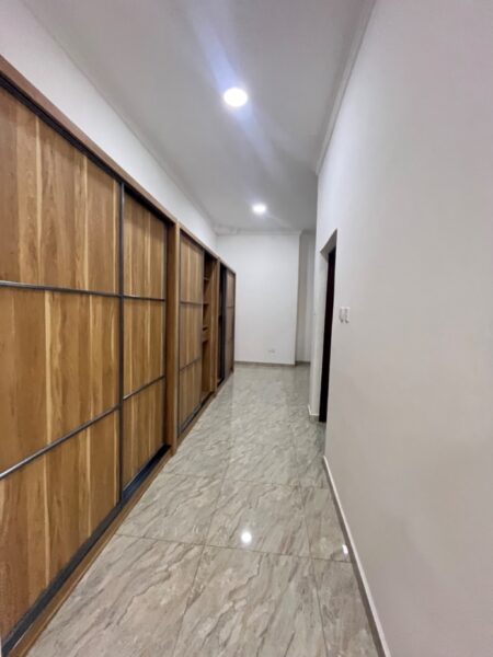 Walk-in closet area with dresser and wooden wardrobes.