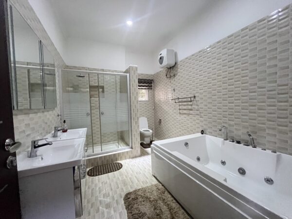 Modern bathroom with jacuzzi tub, dual sink, and shower.