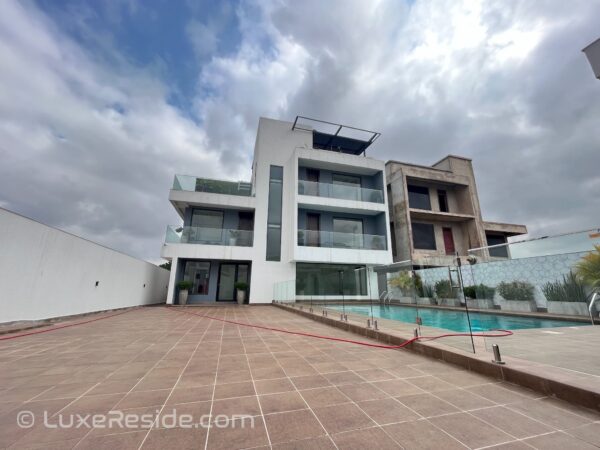 Modern architecture with a large pool area, perfect for outdoor relaxation.