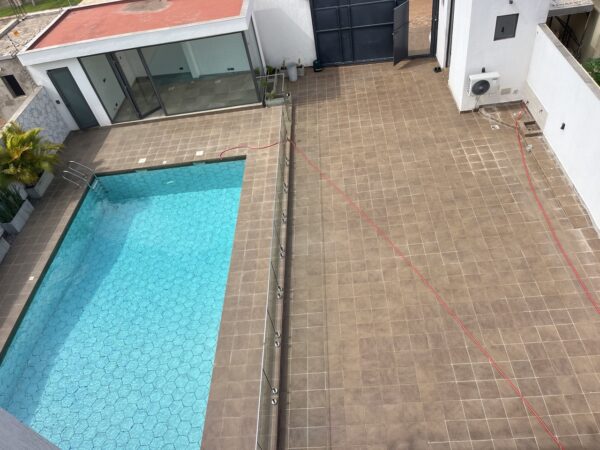 Large private pool with glass fencing and a pool house with separate facilities.