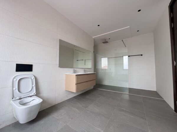 Contemporary en-suite bathroom with a walk-in rain shower and premium finishes.