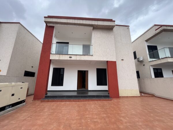 Exterior of the furnished 4-bedroom house, featuring a large paved compound and backup generator.