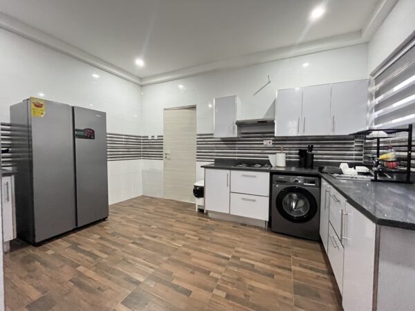 Contemporary kitchen with modern appliances, including a washing machine.