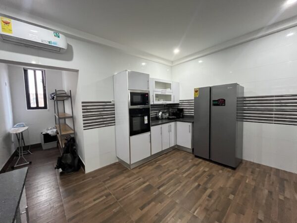 Contemporary kitchen with modern appliances, including a washing machine.
