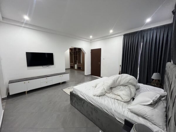 Fully furnished bedroom with modern decor and built-in storage.