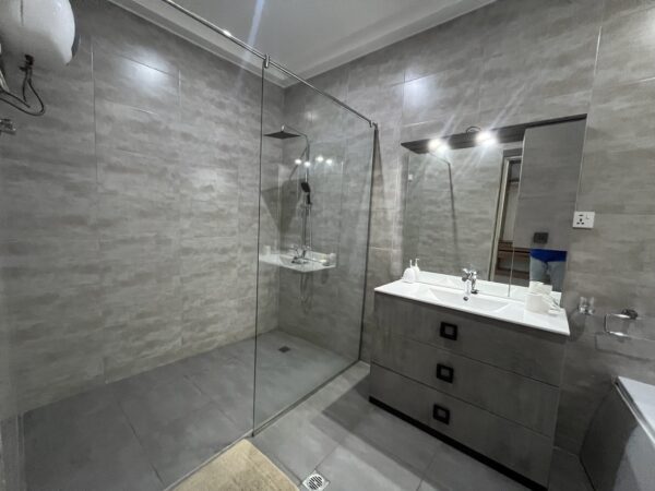 Sleek en-suite bathroom with a walk-in shower and premium fixtures.