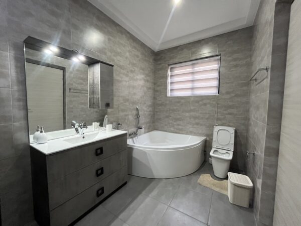 Spacious bathroom featuring a walk-in glass shower and bathtub.