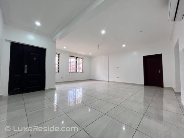 Large tiled living room with multiple windows for natural light