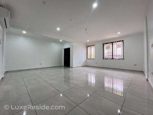 Large tiled living room with multiple windows for natural light
