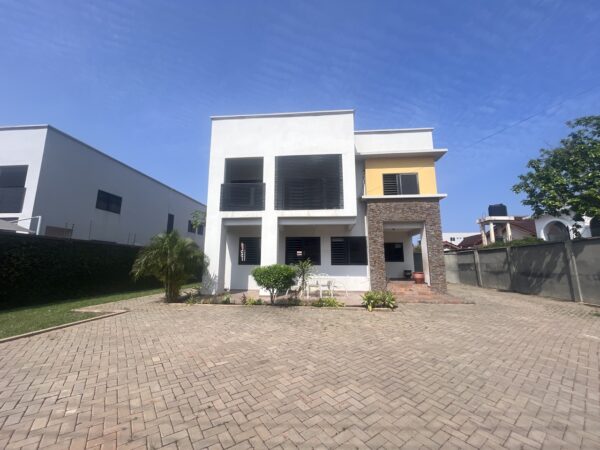 Spacious compound with well-kept lawn and ample parking space.