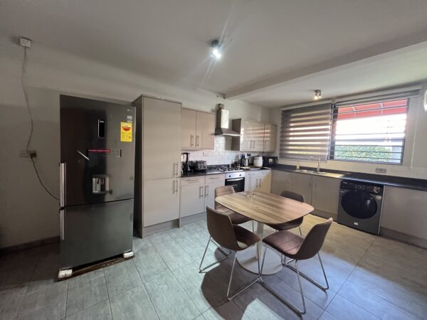 Fully equipped kitchen with modern appliances and dining table.