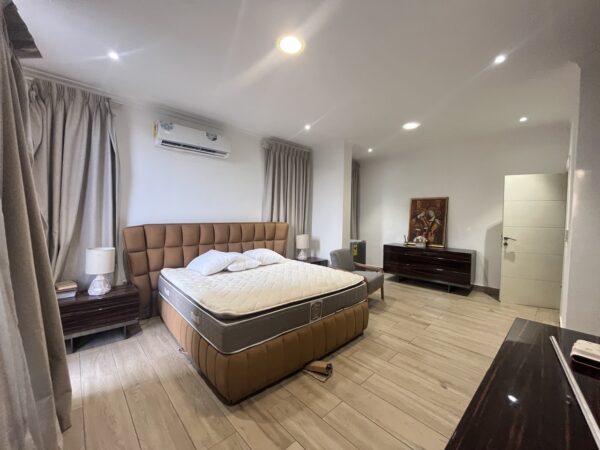 Furnished bedroom with plush bed, nightstands, and ambient lighting.