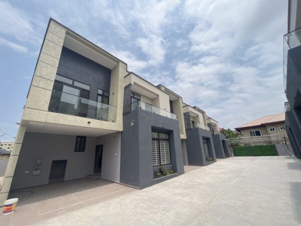 Modern facade with a private glass balcony and secure paved driveway.