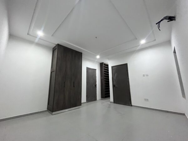 Spacious bedroom with modern finishes and ample storage.