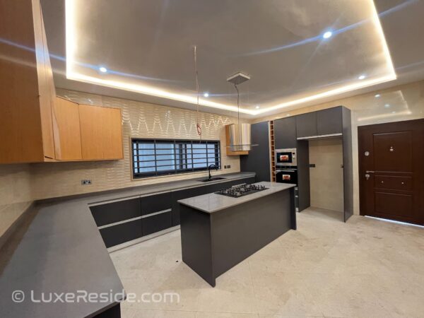 Modern kitchen with an island, built-in oven, and stylish lighting