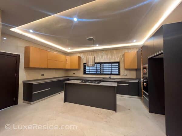 Modern kitchen with an island, built-in oven, and stylish lighting