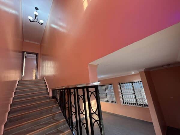 Staircase leading to the upper level with a high ceiling and chandelier.