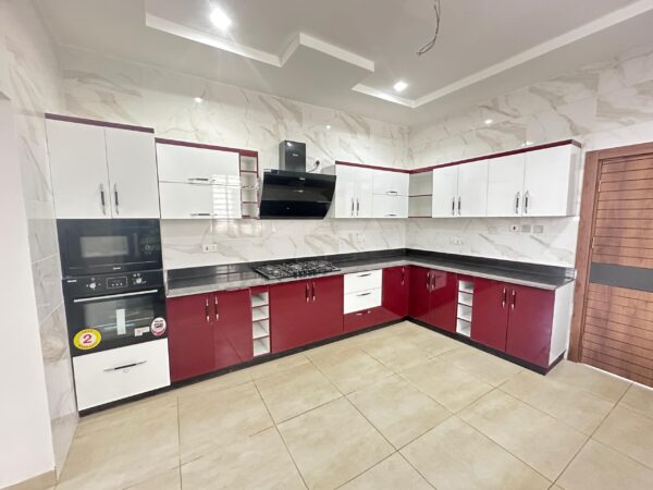 Fully equipped modern kitchen with sleek red and white cabinetry.